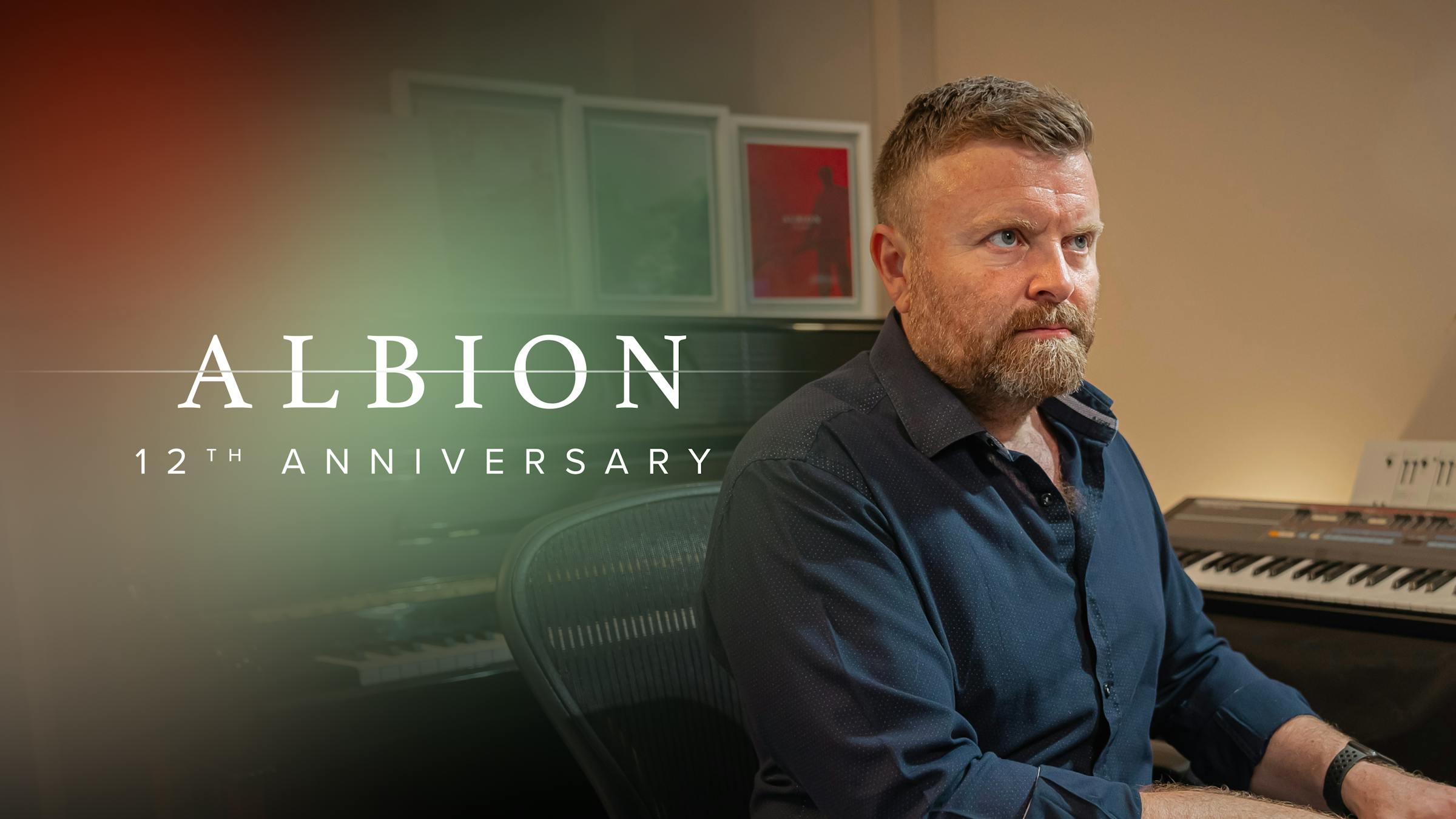 Paul Thomson sat at desk. Text reads "Albion 12th anniversary".