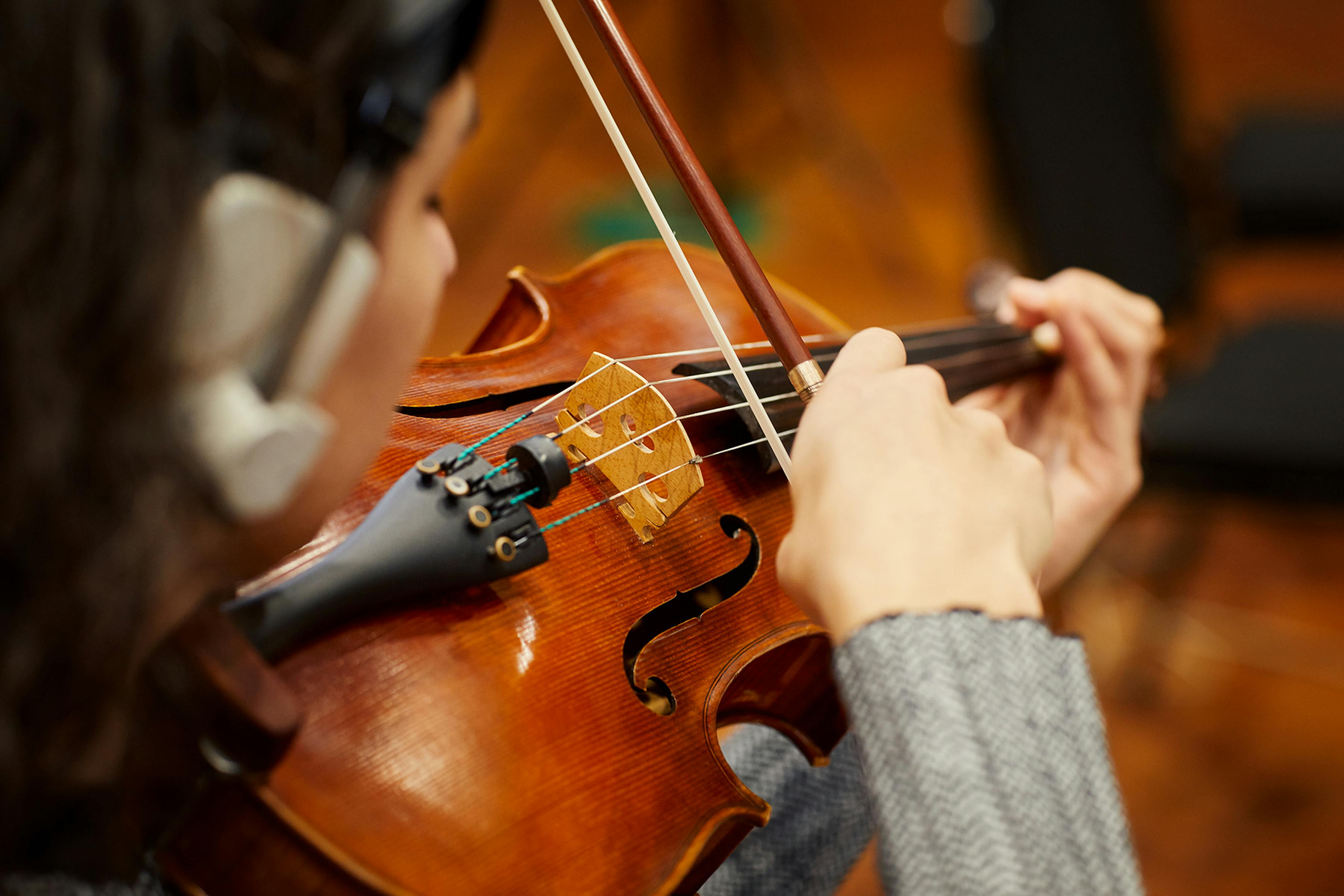 Woman gently bowing violin strings