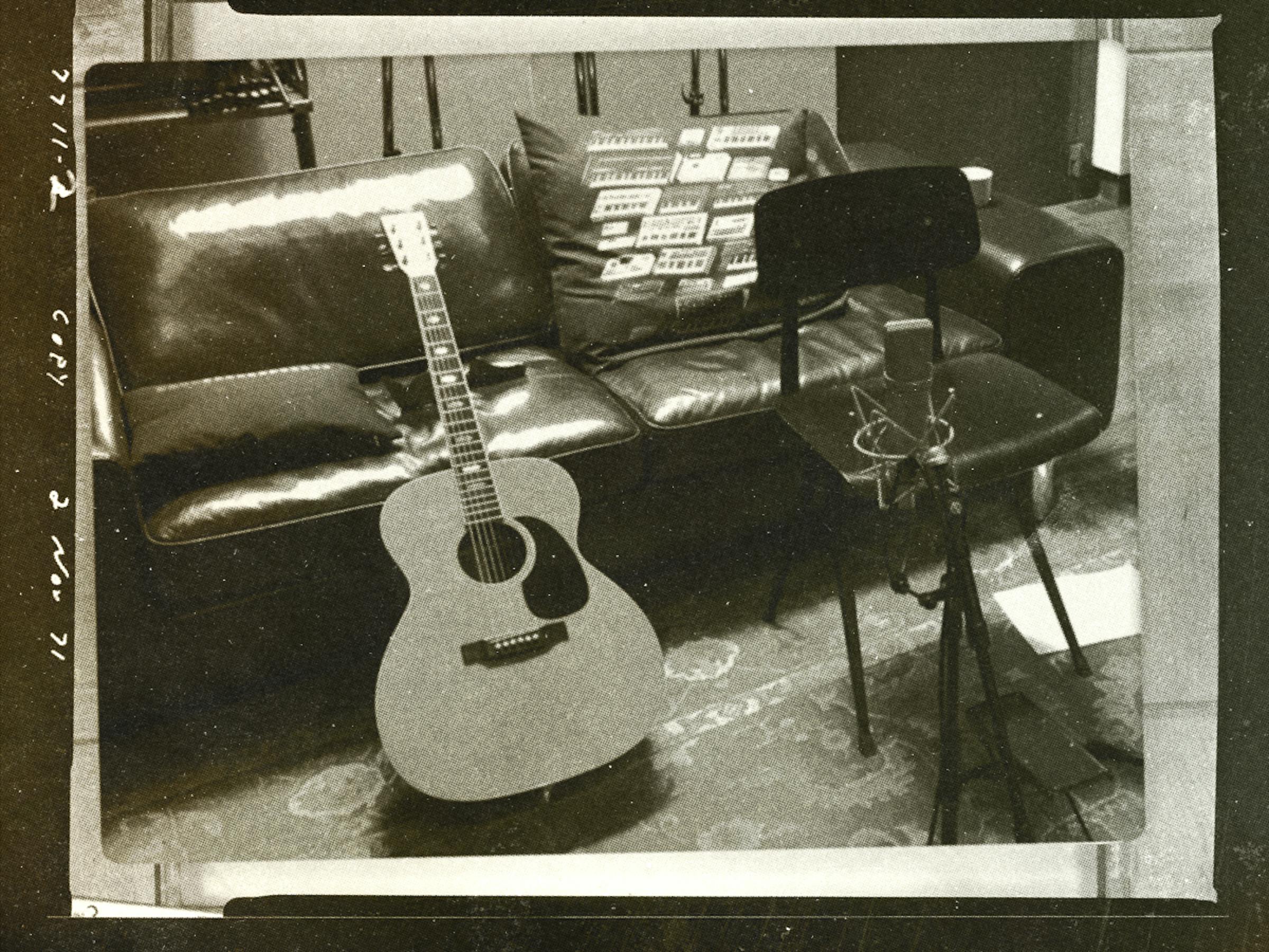 Guitar leaning against soft in studio